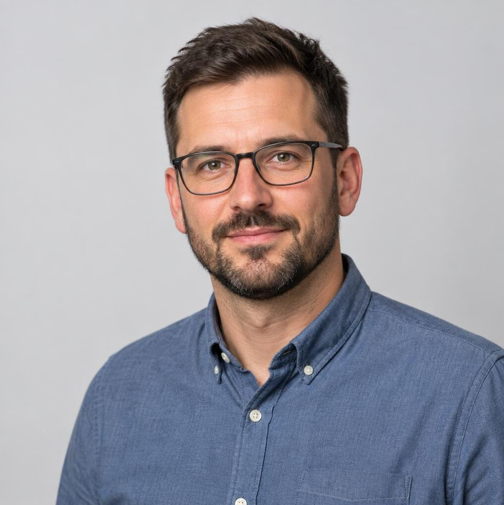 Studio portrait of a man with a beard and glasses